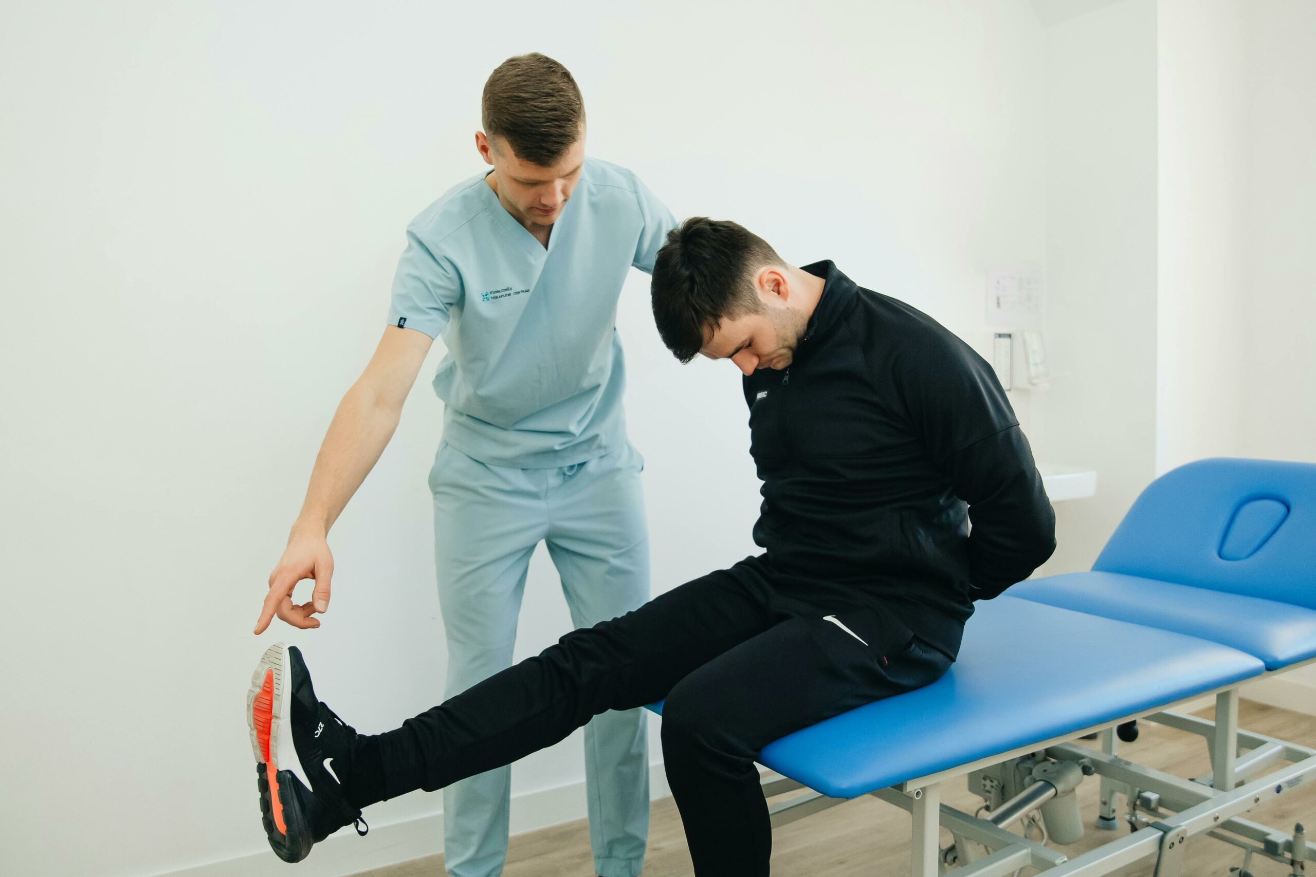 Physiotherapist instructing a patient on rehabilitation exercises in a clinic setting.